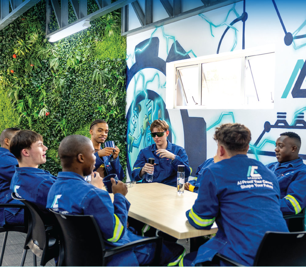 Students in overalls talking around a table