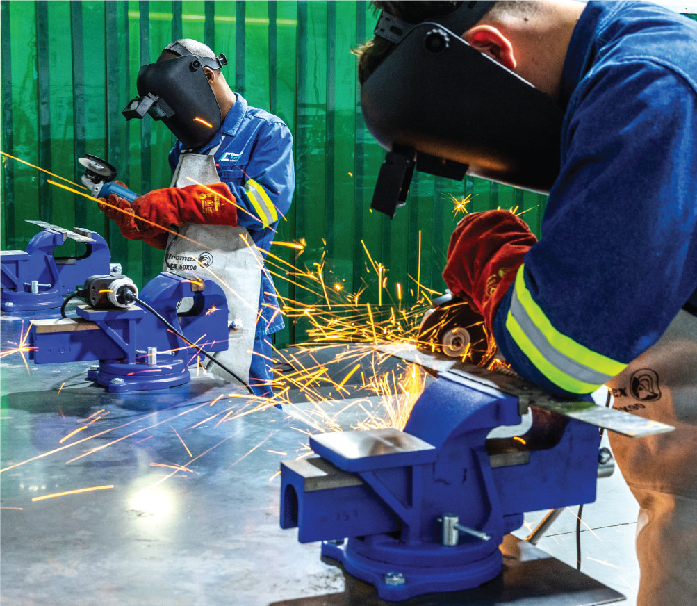 Student grinding metal in the workshop